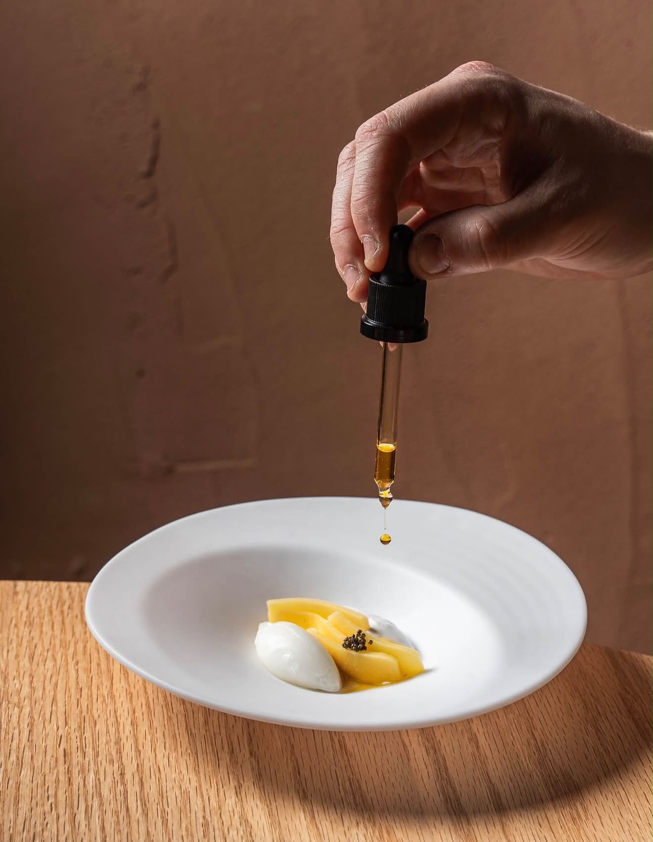 Una gota de aceite cae de un cuentagotas sobre un plato