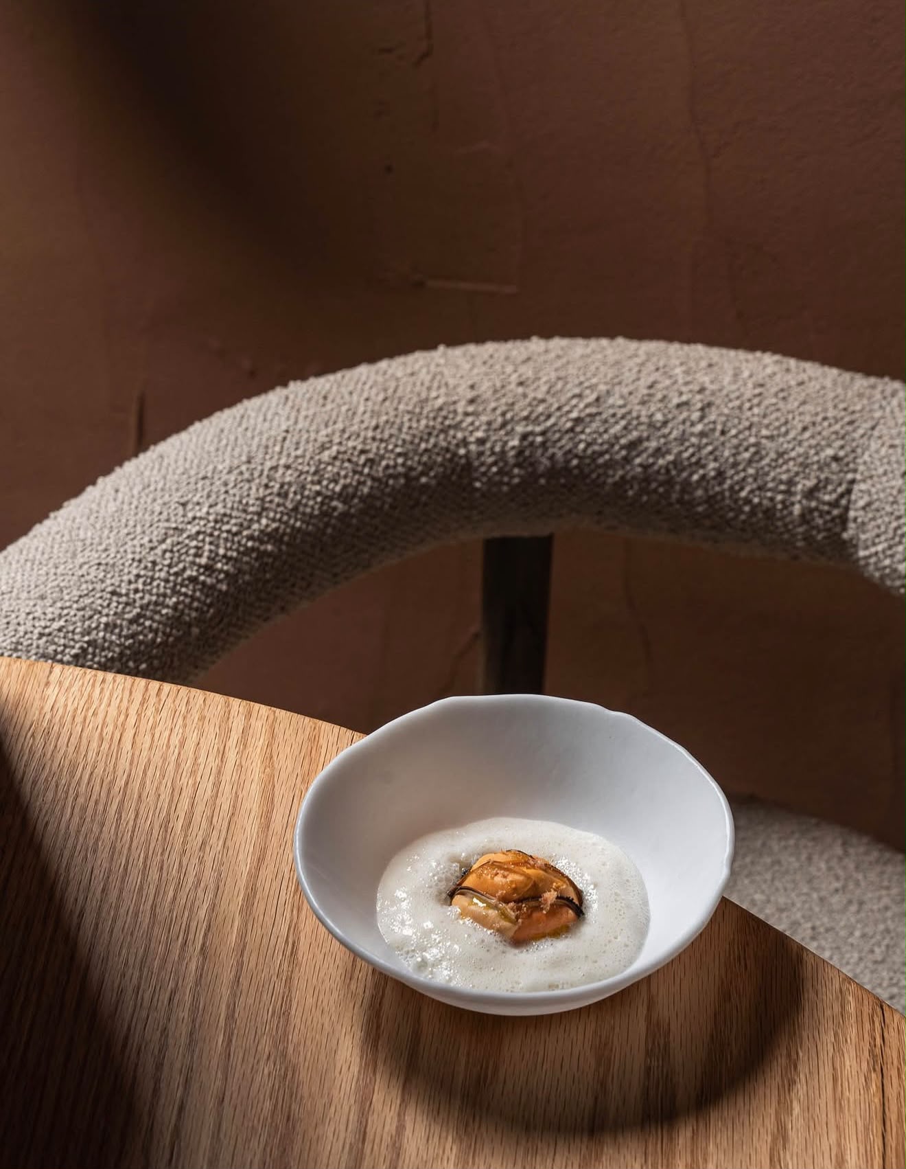 Cuenco con mejillón y espuma sobre la mesa